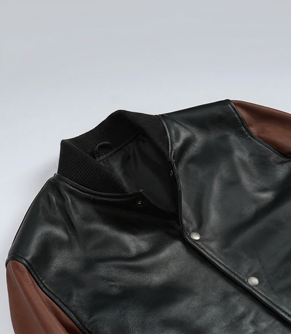 Varsity Bomber Jacket – Detail Shot Close-up detail of Varsity Bomber Jacket snap buttons and rib-knit collar