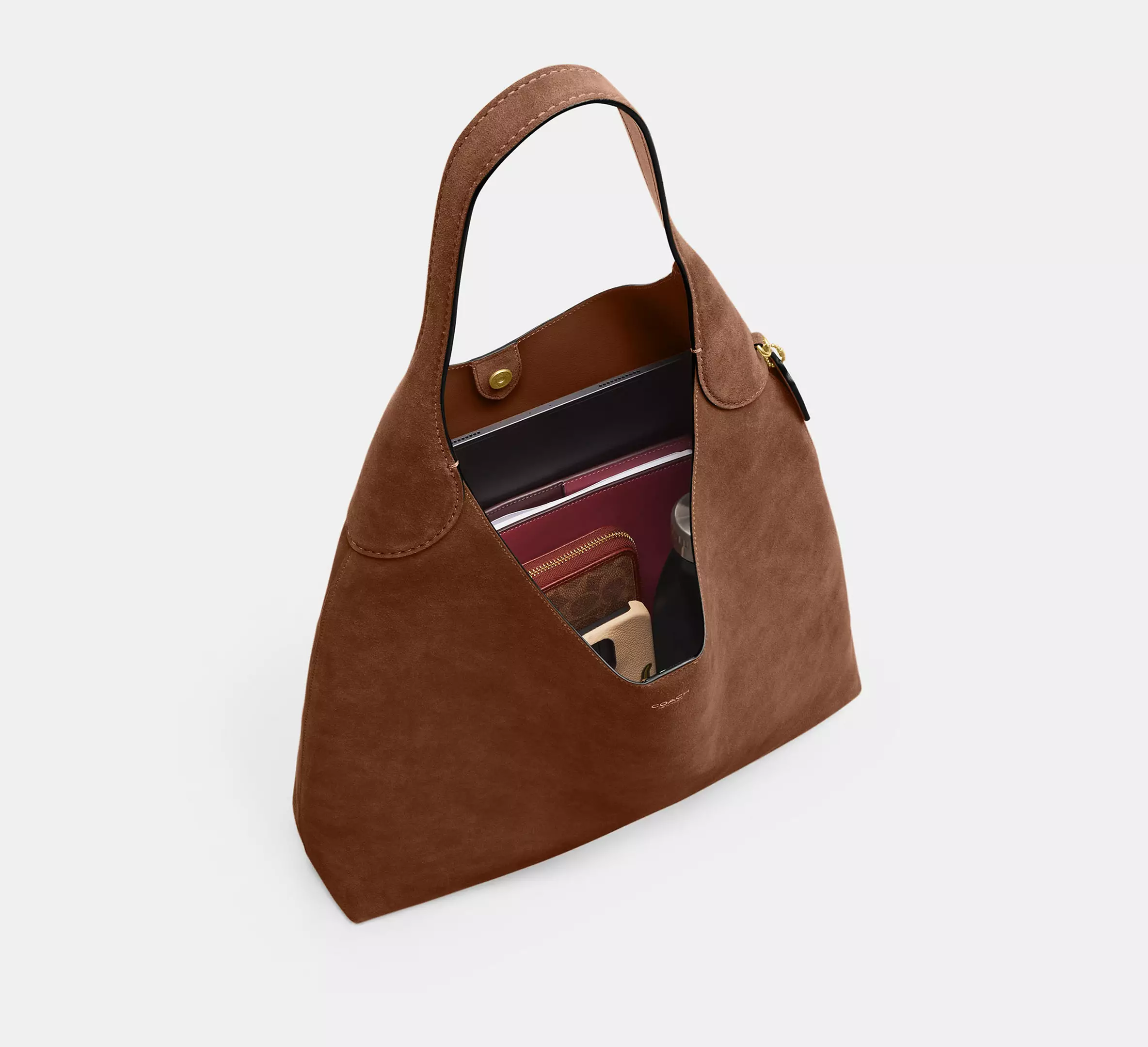 Woman carrying oversized soft leather hobo bag over the shoulder Woman carrying oversized soft leather hobo bag over the shoulder